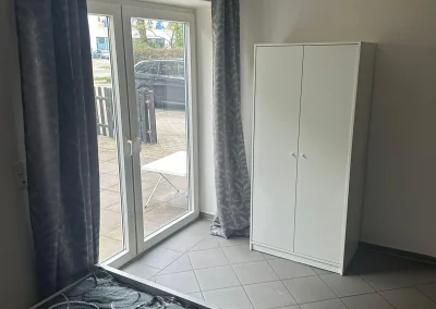 Zimmer mit Schrank und Zugang zum Außenbereich in Monteurwohnung 2 in Delmenhorst