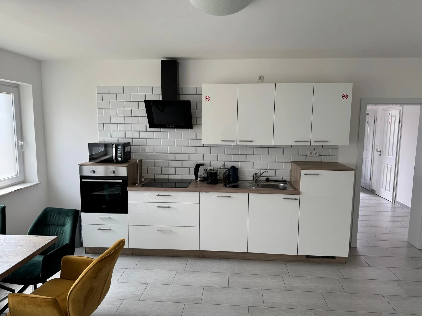 Moderne weiße Küche mit Dunstabzug in Monteurwohnung 3 in Delmenhorst