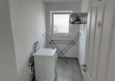 Waschraum mit Waschmaschine und Wäscheständer in Monteurwohnung 3 in Delmenhorst