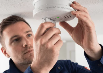 Servicemonteur der TH Objekt Service GmbH montiert einen Rauchwarnmelder an einer Zimmerdecke in Delmenhorst